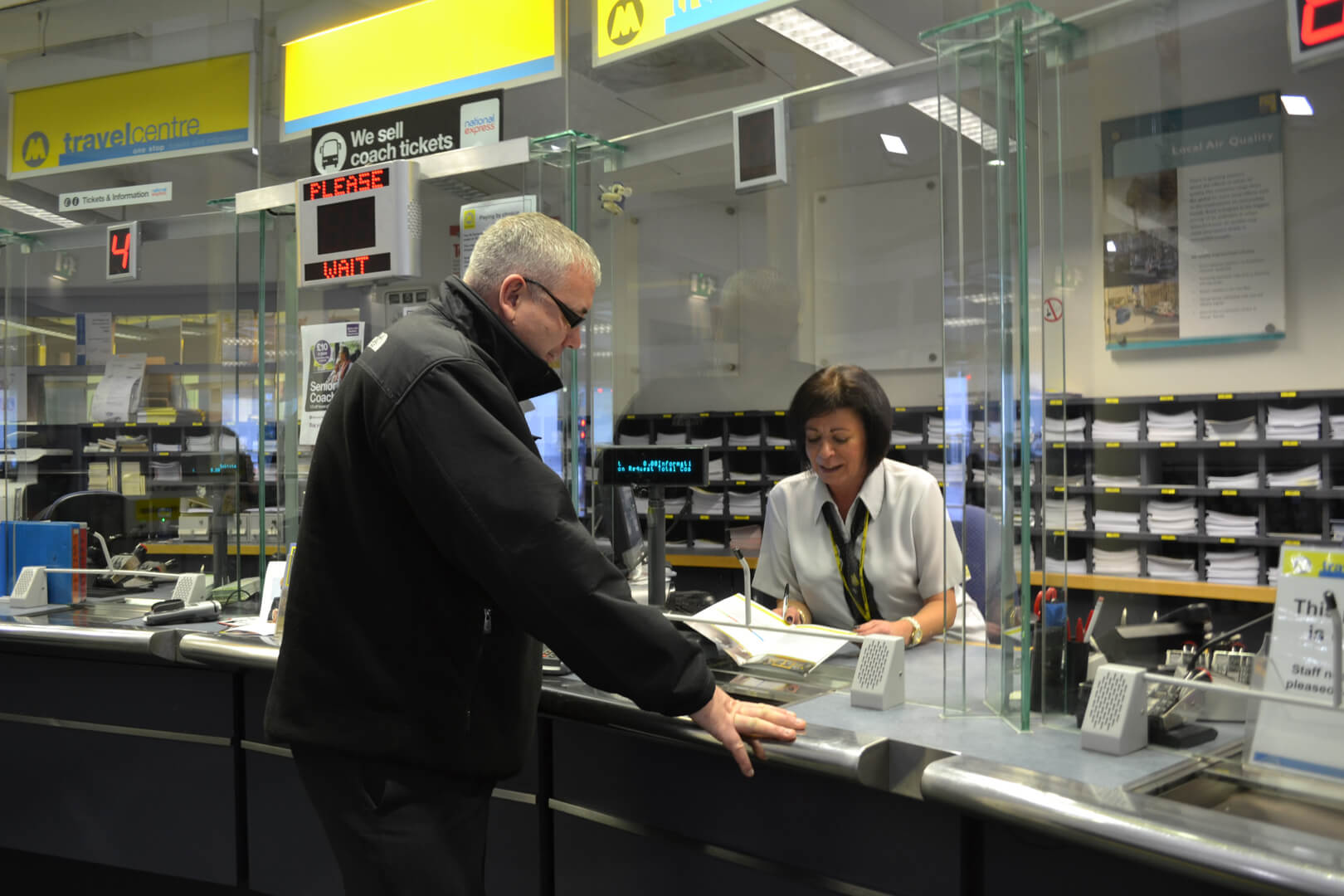 Picture of a person being served and speaking to a member of Merseytravel staff at a Travel Centre